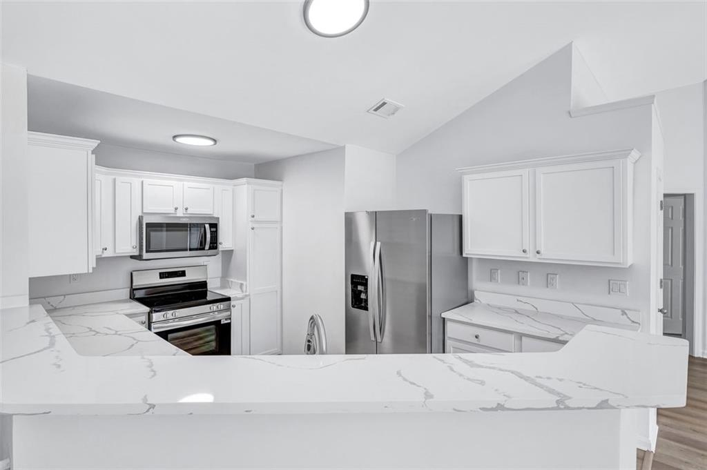 2540 Willow Grove Road, Unit 15 Acworth, GA 30101 - Photo 4 of 35 a kitchen with stainless steel appliances kitchen island granite countertop a refrigerator and a stove top oven