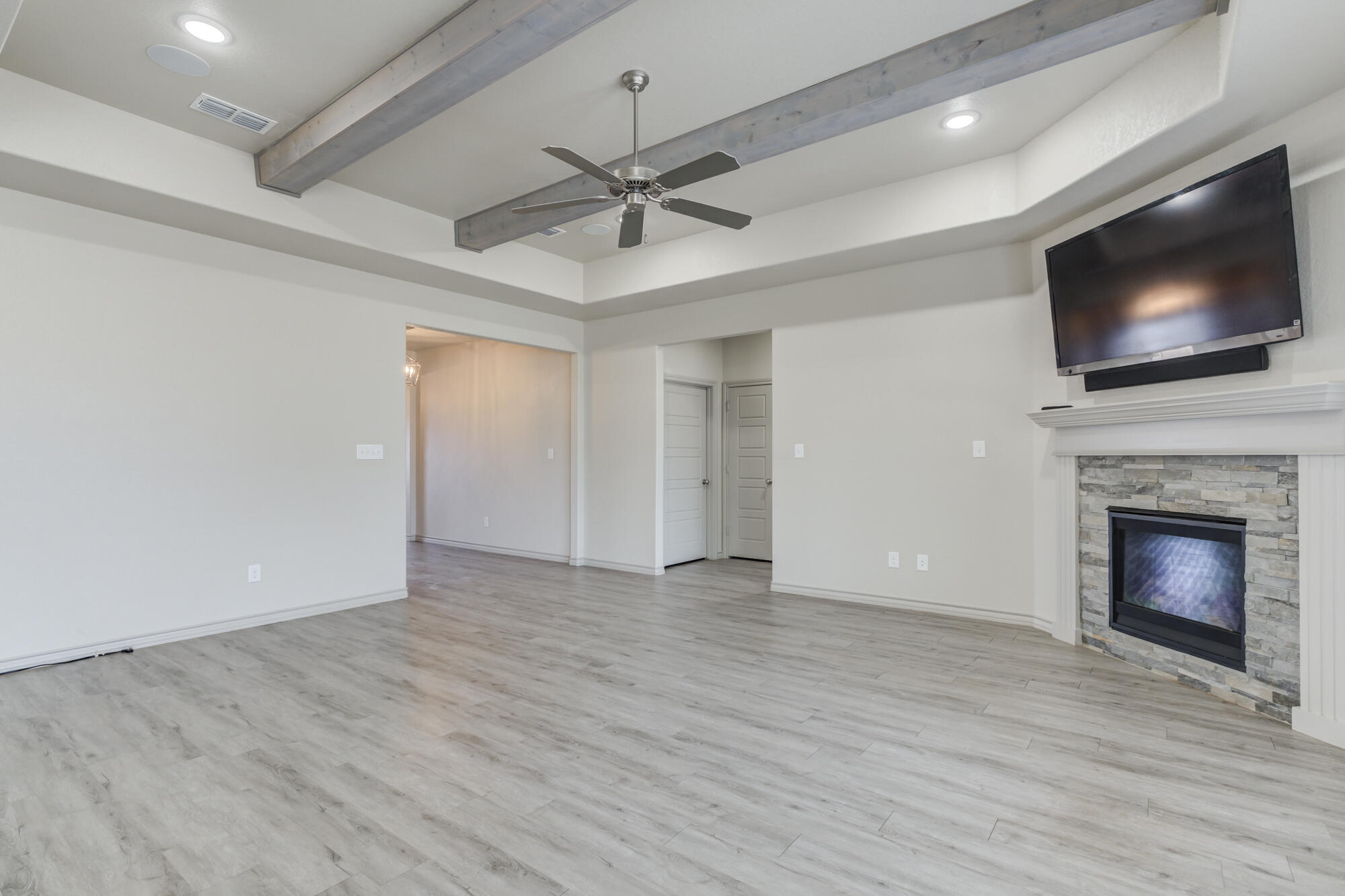 7614 62nd Street Lubbock, TX 79407 - Photo 11 of 54 a view of an empty room with wooden floor a fireplace and a window
