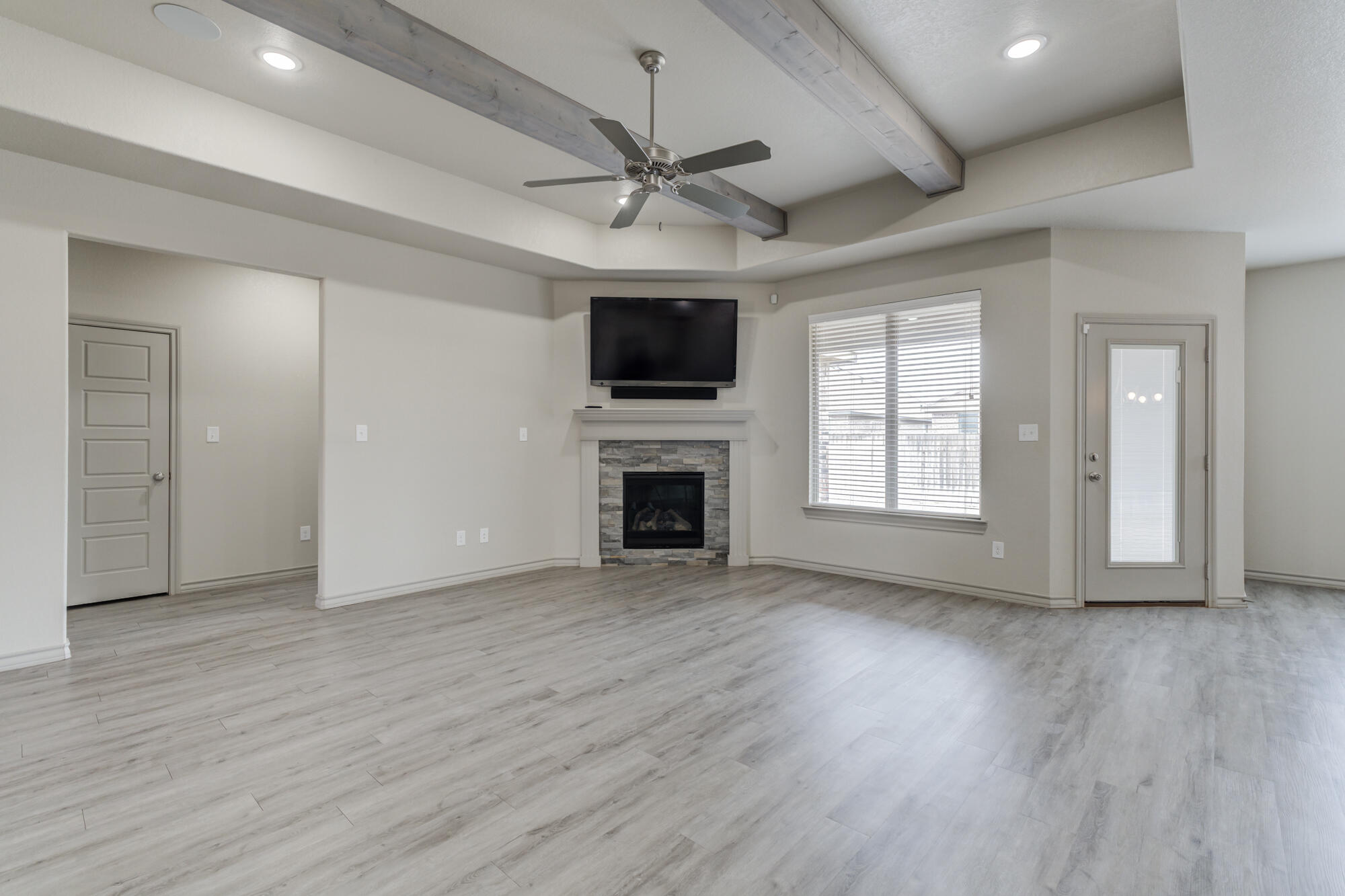 7614 62nd Street Lubbock, TX 79407 - Photo 19 of 54 a view of an empty room with wooden floor fireplace and a window