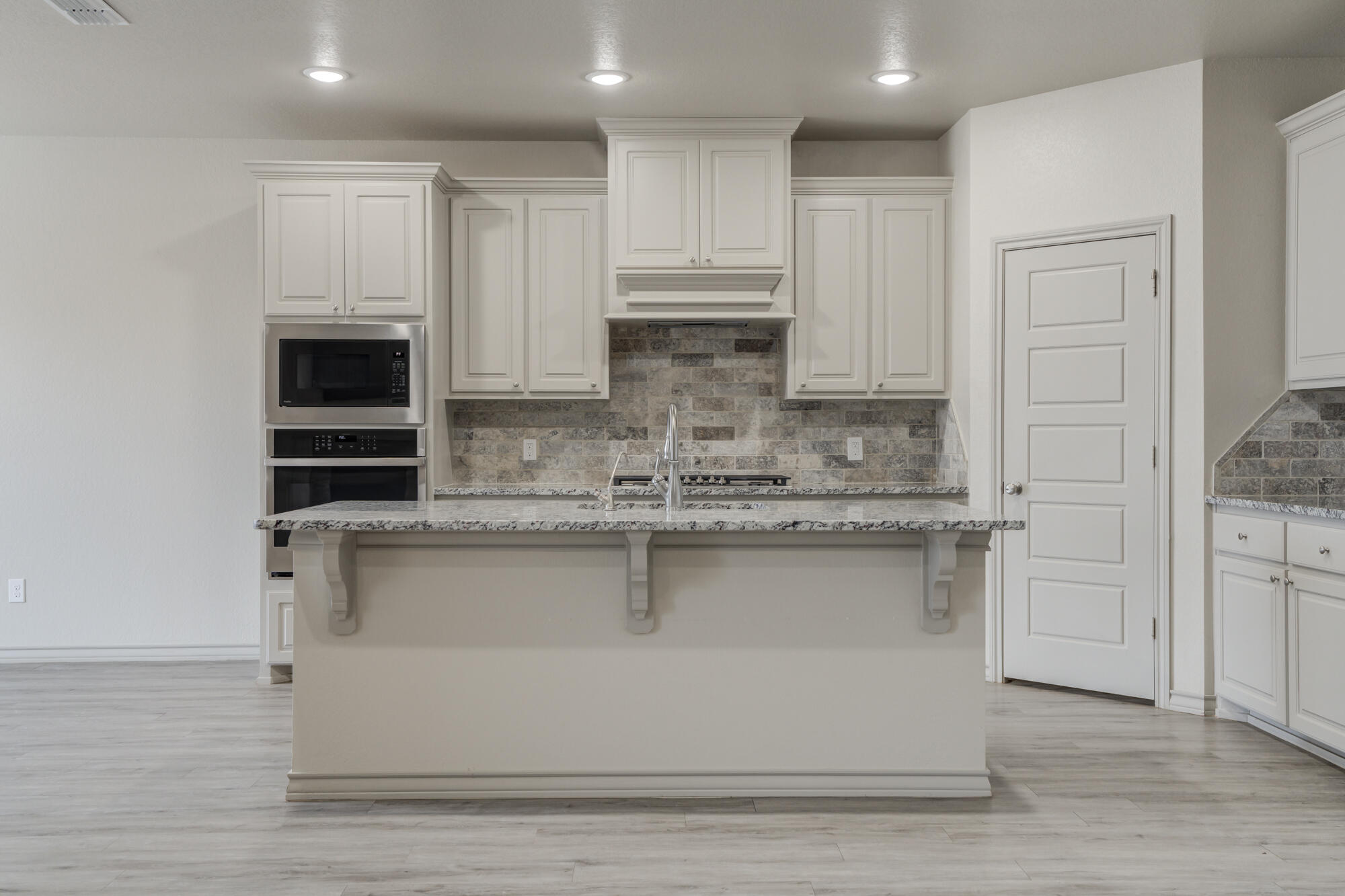 7614 62nd Street Lubbock, TX 79407 - Photo 25 of 54 a kitchen with stainless steel appliances granite countertop a stove a sink and a microwave