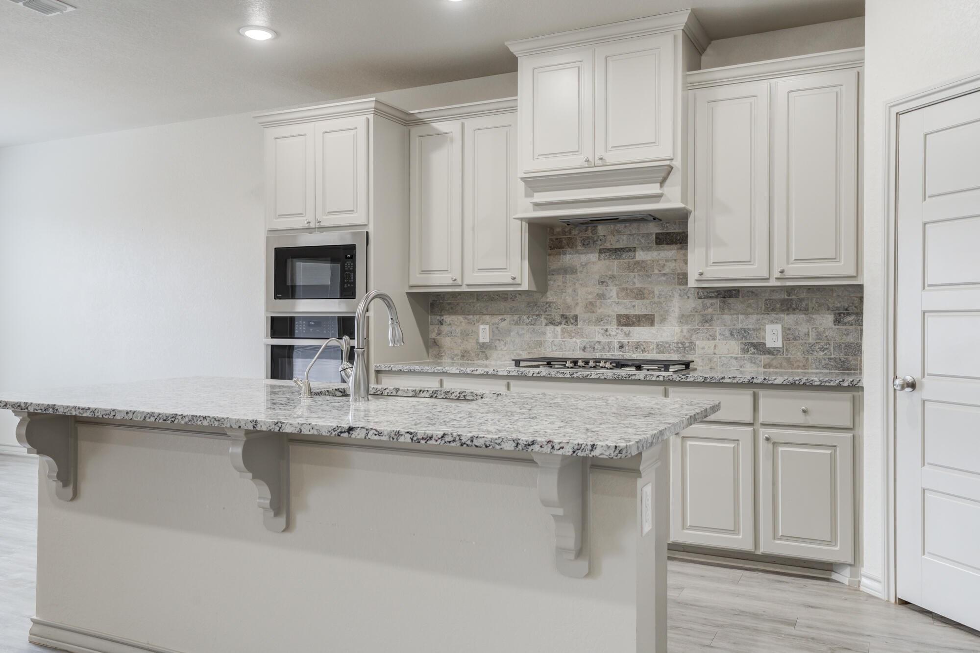 7614 62nd Street Lubbock, TX 79407 - Photo 26 of 54 a kitchen with granite countertop a sink and cabinets