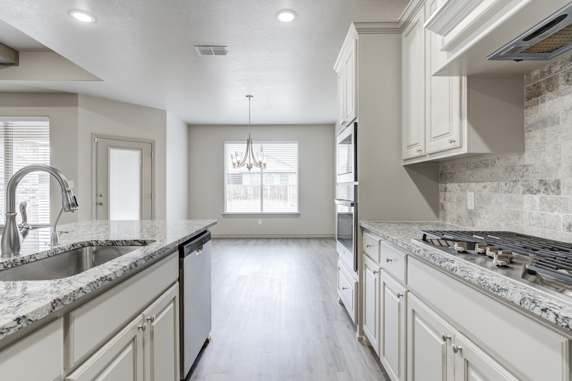 7614 62nd Street Lubbock, TX 79407 - Photo 29 of 54 a kitchen with granite countertop a stove and a sink