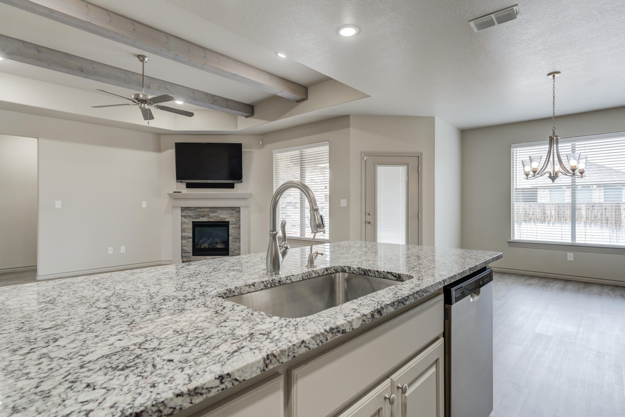 7614 62nd Street Lubbock, TX 79407 - Photo 30 of 54 a kitchen with granite countertop a sink and a stove top oven