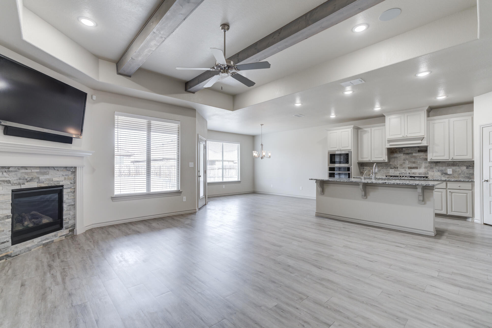 7614 62nd Street Lubbock, TX 79407 - Photo 3 of 54 a view of an empty room with wooden floor and a kitchen