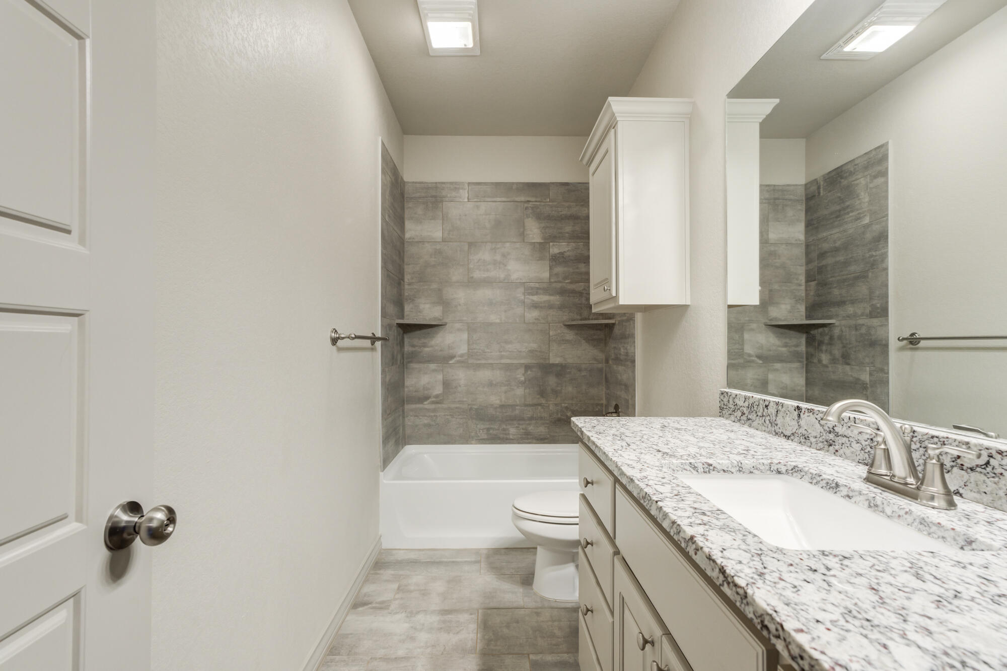 7614 62nd Street Lubbock, TX 79407 - Photo 44 of 54 a bathroom with a granite countertop sink a toilet and shower
