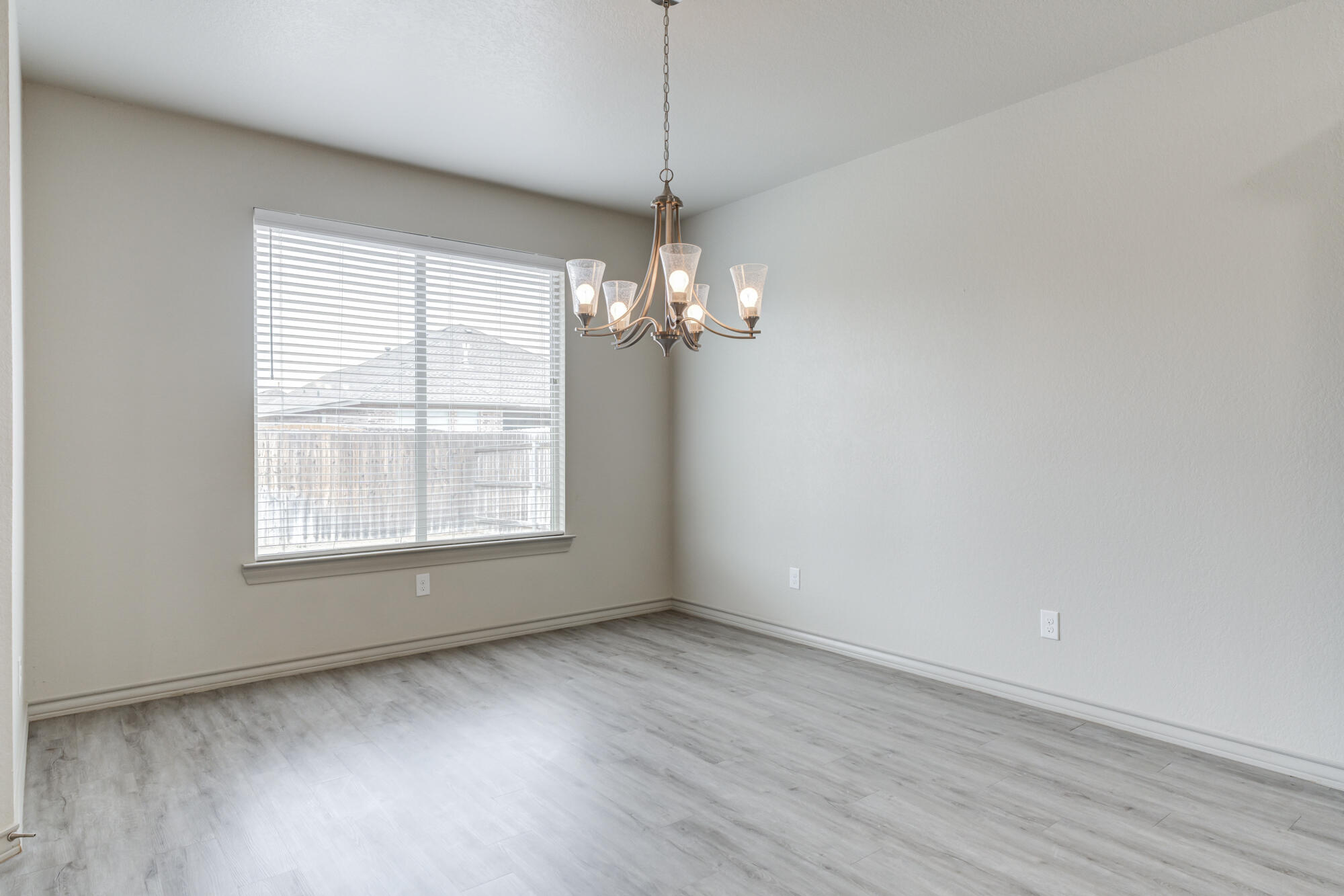 7614 62nd Street Lubbock, TX 79407 - Photo 9 of 54 a view of a room with wooden floor and chandelier