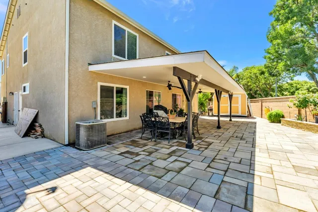 a view of a patio with table and chairs near a barbeque