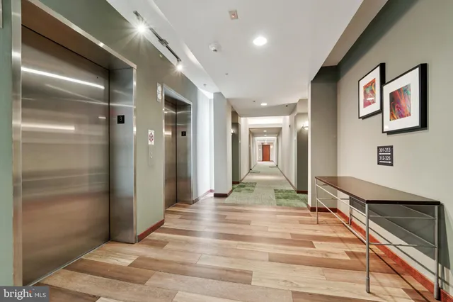 a view of a hallway with wooden floor and staircase