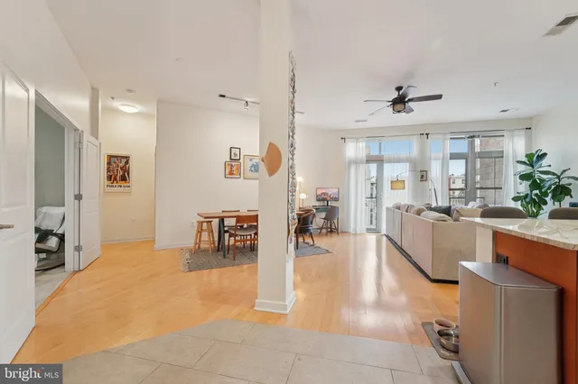 a living room with furniture and a dining table with wooden floor