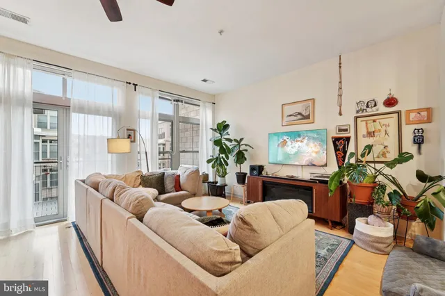 a living room with furniture a flat screen tv and a large window