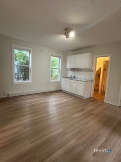 44 Prest Street, Unit 1 New London, CT 06320 - Photo 2 of 9 an empty room with wooden floor and a window