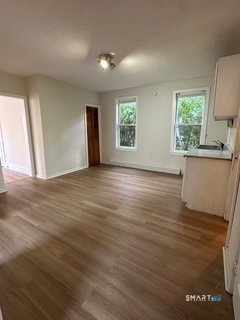 44 Prest Street, Unit 1 New London, CT 06320 - Photo 3 of 9 an empty room with wooden floor and windows
