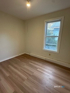 44 Prest Street, Unit 1 New London, CT 06320 - Photo 5 of 9 an empty room with wooden floor and windows