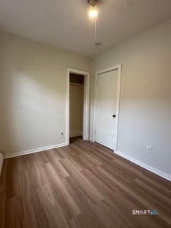 44 Prest Street, Unit 1 New London, CT 06320 - Photo 7 of 9 an empty room with wooden floor and windows