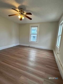 44 Prest Street, Unit 1 New London, CT 06320 - Photo 9 of 9 an empty room with wooden floor fan and windows