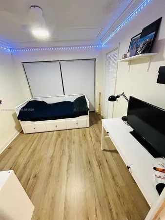a living room with a bed furniture and a flat screen tv