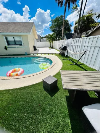 a view of backyard with a white fence