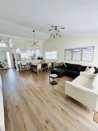 a living room with furniture and a chandelier