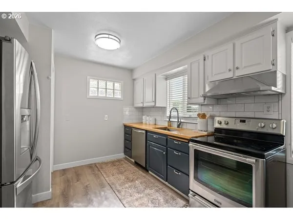 a kitchen with stainless steel appliances granite countertop a stove a sink and a refrigerator