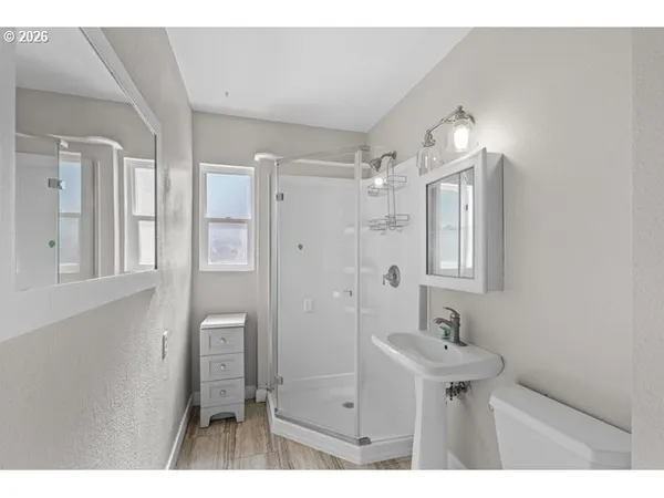 a bathroom with a sink mirror and shower