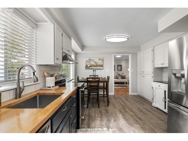561 East Ridgeway Avenue Hermiston, OR 97838 - Photo 9 of 46 a kitchen with a table chairs microwave and cabinets