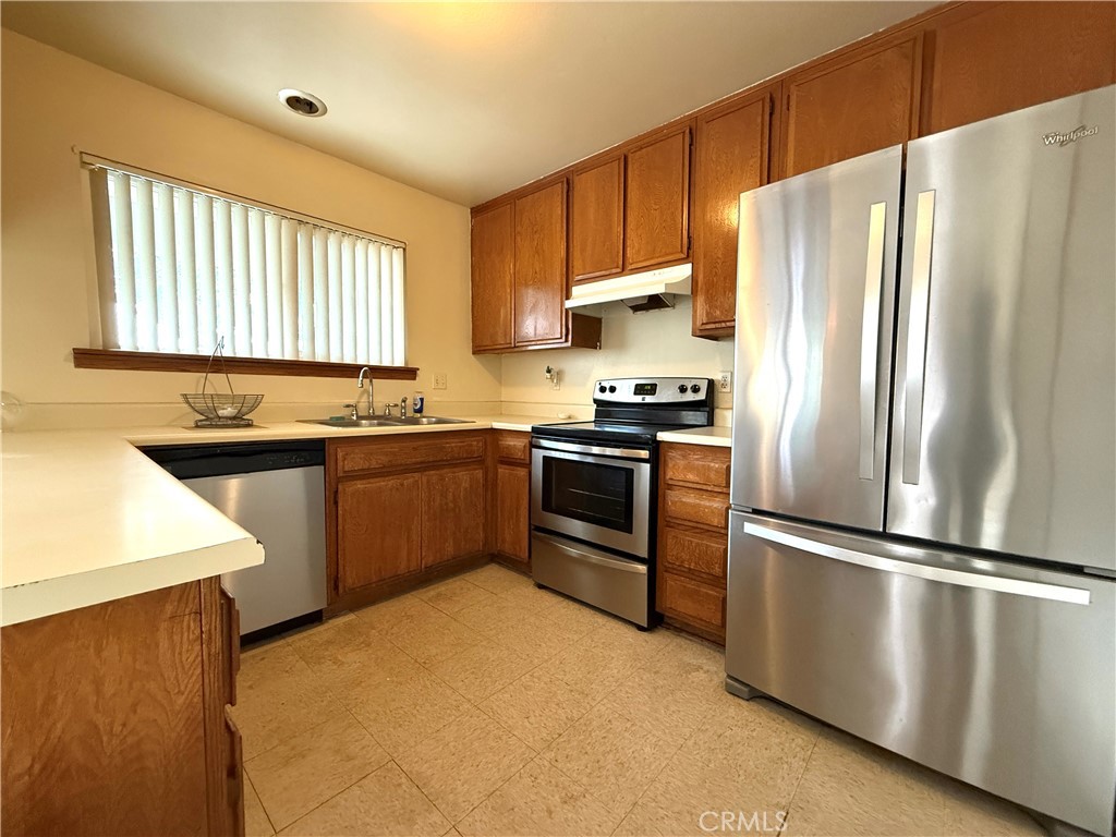 860 Cinnamon Lane, Unit 55 Duarte, CA 91010 - Photo 4 of 13 a kitchen with stainless steel appliances granite countertop a refrigerator a sink dishwasher a stove top oven a refrigerator with island and chairs