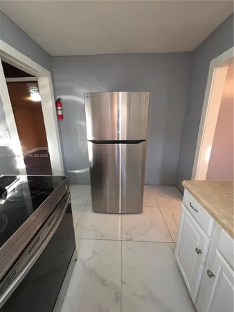 a kitchen with stainless steel appliances granite countertop a refrigerator and a stove