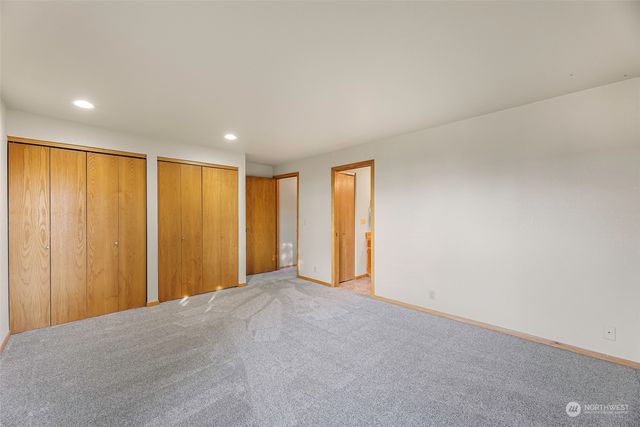 a spacious bedroom with a bed and painting on the wall