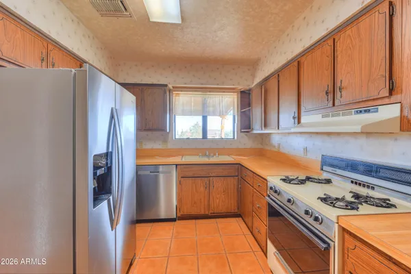 a kitchen with stainless steel appliances granite countertop a refrigerator stove and sink