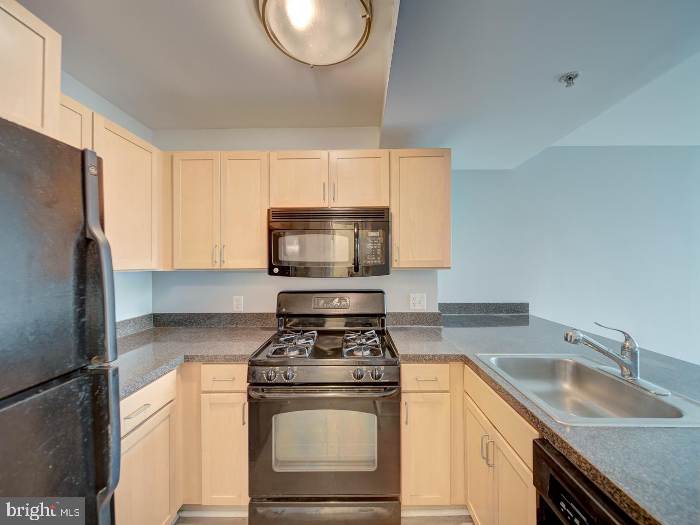 800 4th Street Southwest, Unit N703 Washington, DC 20024 - Photo 13 of 25 a kitchen with granite countertop a sink stainless steel appliances and cabinets