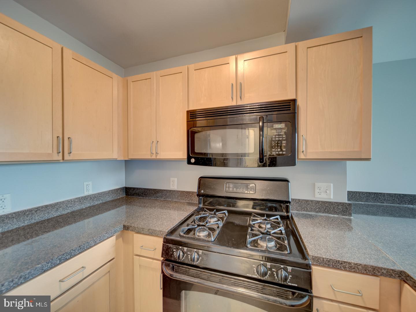 800 4th Street Southwest, Unit N703 Washington, DC 20024 - Photo 15 of 25 a kitchen with granite countertop a stove a sink and a microwave