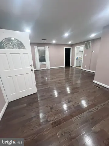 an empty room with wooden floor and white walls