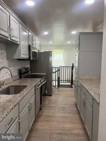 a kitchen with stainless steel appliances granite countertop a sink and a stove
