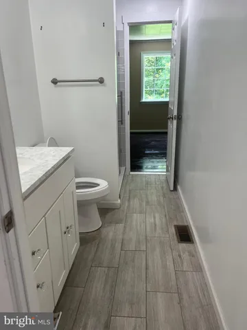 a bathroom with a sink a toilet and a window