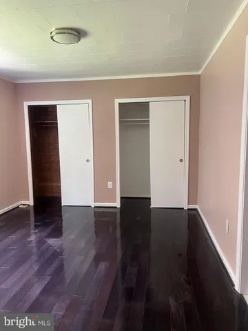 an empty room with wooden floor and closet