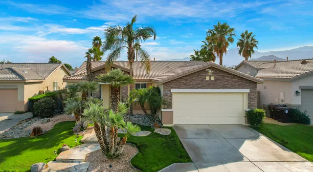 a front view of a house with a yard and potted plants