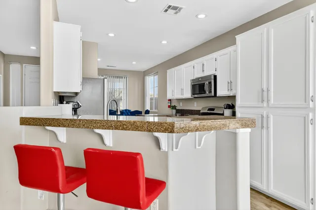 a large kitchen with stainless steel appliances granite countertop a stove a sink and a microwave