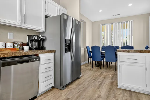 a kitchen with stainless steel appliances granite countertop a refrigerator and a stove top oven