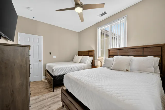 a bedroom with two beds and a flat screen tv