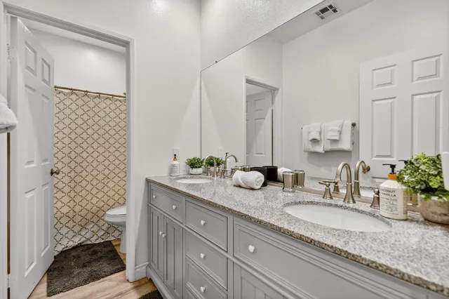 a bathroom with a granite countertop sink and a mirror