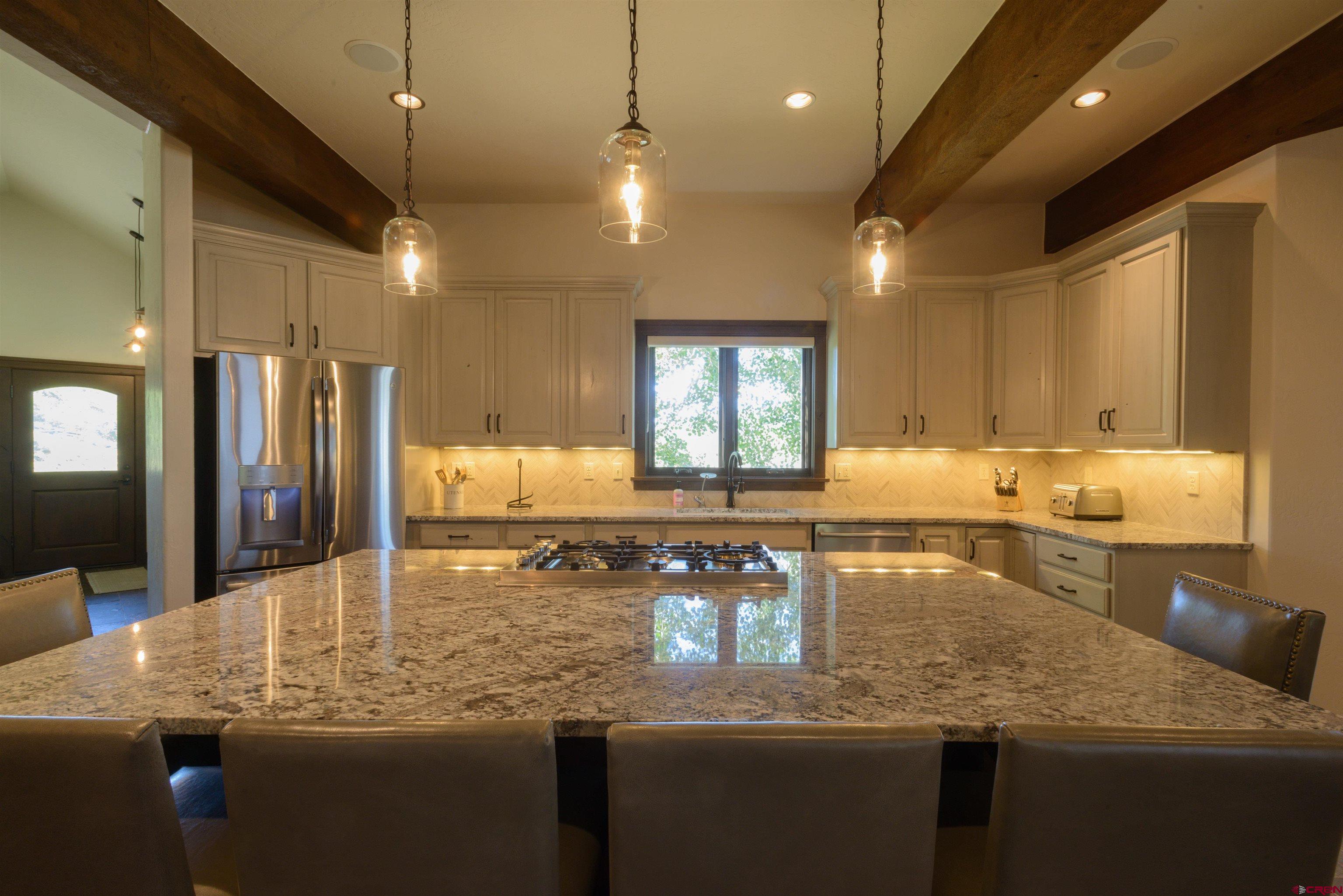 660 Lower Highlands Road Crested Butte, CO 81224 - Photo 15 of 31 a kitchen with stainless steel appliances granite countertop a sink refrigerator and cabinets