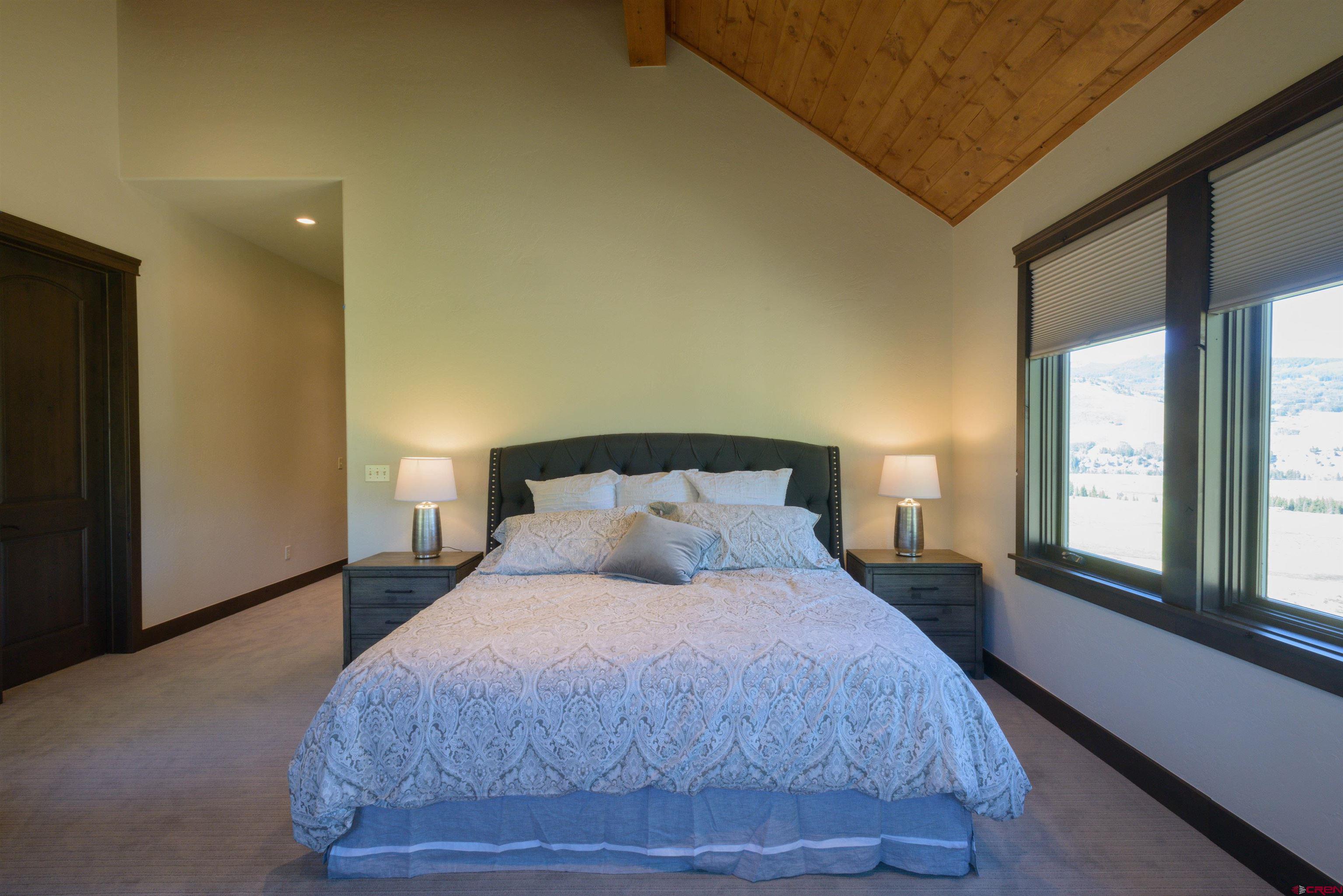 660 Lower Highlands Road Crested Butte, CO 81224 - Photo 20 of 31 a bedroom with a large bed and a large window