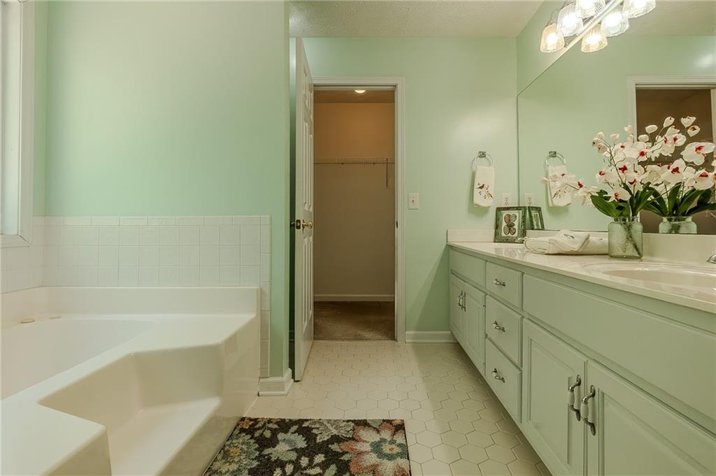 160 Vinny's Way Covington, GA 30014 - Photo 19 of 51 a bathroom with a double vanity sink a toilet and shower