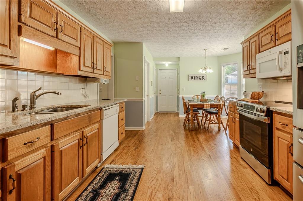 160 Vinny's Way Covington, GA 30014 - Photo 8 of 51 a kitchen with stainless steel appliances granite countertop sink stove top oven and cabinets