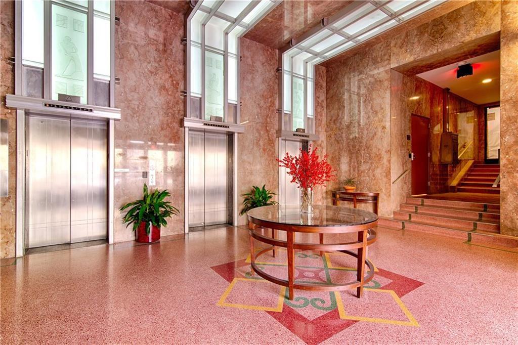 710 Colorado Street, Unit G9 Austin, TX 78701 - Photo 24 of 25 A grand lobby with marble walls and a decorative terrazzo floor welcomes residents and guests with two sleek elevators and a gracefully ascending staircase.