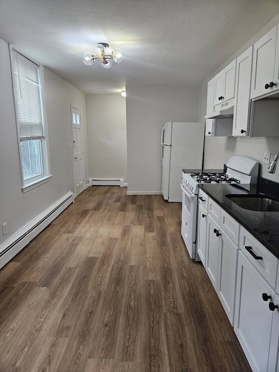 33 Rockland Street, Unit 2 Canton, MA 02021 - Photo 2 of 10 a kitchen with granite countertop wooden floors a stove and white cabinets