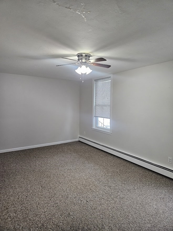 33 Rockland Street, Unit 2 Canton, MA 02021 - Photo 6 of 10 an empty room with a chandelier fan and windows
