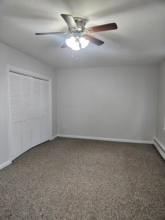 an empty room with a ceiling fan and a window