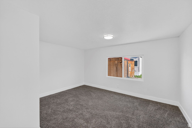 2491 Highway 89, Unit 523 Pleasant View, UT 84404 - Photo 15 of 31 Spare room featuring baseboards and dark colored carpet