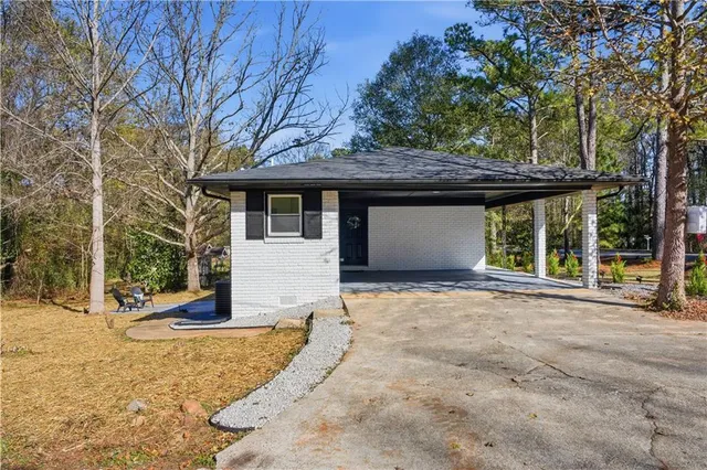 a view of a house with a yard and large tree